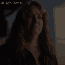 a woman is crying in a dark room with #highcastle on the bottom