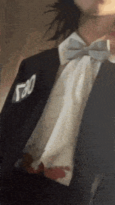 a man wearing a suit and bow tie has a patch on his jacket that says ' 780 ' on it