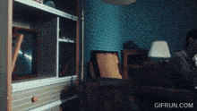a man sits on a couch in a living room with a gif run.com watermark