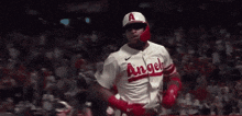 a baseball player for the angels is wearing a red helmet