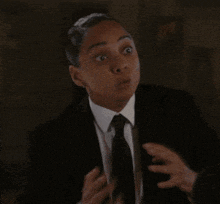 a woman in a suit and tie says " why is he so bad at this "