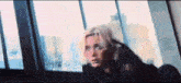 a woman is looking out of a window in a room .