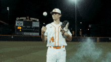 a baseball player wearing a white jersey with the number 14 on it