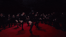 a group of women are dancing on the red carpet