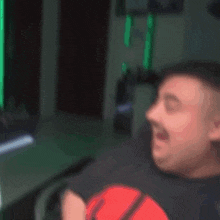 a blurry picture of a man sitting in a chair with a green light behind him
