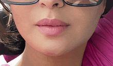 a close up of a woman 's face with glasses and pink lips