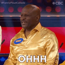 a man in a gold shirt with the word ohhh on his chest