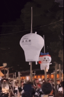 a group of people are watching a balloon being lit up