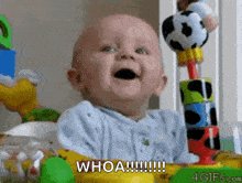 a baby is sitting in a crib with toys and says whoa
