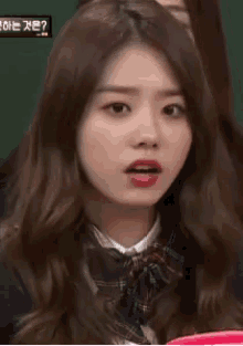 a girl in a school uniform is making a funny face .