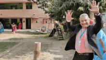 a man in a suit and tie is waving his hands in front of a playground .