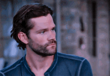 a man with a beard wearing a blue shirt