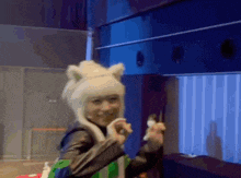 a woman wearing a cat costume is holding a toy in her hand .