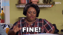 a woman in a plaid shirt with the word fine on her shirt