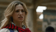 a woman with a scarf around her neck looks very sad