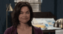 a woman in a purple sweater is making a funny face with abc in the corner