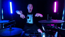 a man wearing a shirt with the letter f on it is playing drums