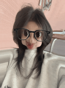 a girl wearing glasses and a sweater that says ' l' amour ' on it