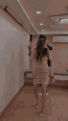 a man in a suit and a woman in a dress are dancing in a hallway