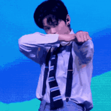 a man wearing suspenders and a striped tie is dancing