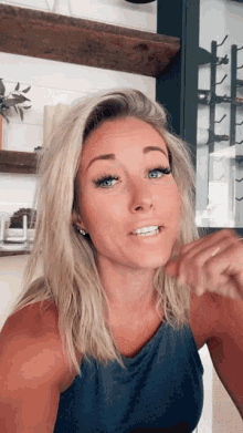 a woman with blonde hair and blue eyes is smiling for the camera