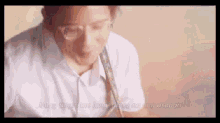 a man with glasses is playing an acoustic guitar .