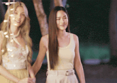 two women holding hands with a watermark that says lingofans on the bottom right