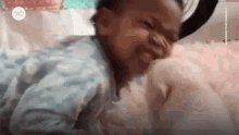 a baby is laying on a bed with a stuffed animal and eating it .