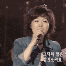 a woman is singing into a microphone with the words royal family written on her arm