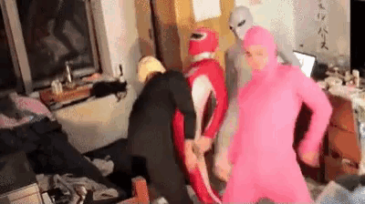a group of people in costumes are standing in a room .