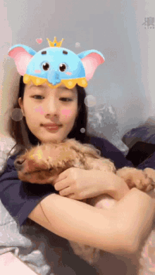 a woman wearing a blue elephant mask holds a small dog
