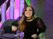 a woman wearing headphones and a choker is dancing in a chair .