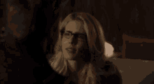 a man and a woman are looking at each other in a dark room .