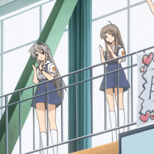 two anime girls are standing on a balcony with a sign that says ' i love you ' on it