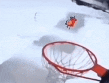 a basketball is going through a basketball hoop on a white surface