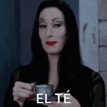 a woman is holding a cup of tea with the word el te written on it .