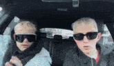 two boys wearing sunglasses are in a car
