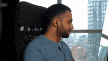 a man wearing headphones is sitting in front of a large window