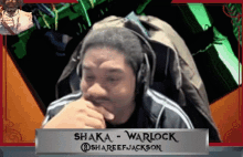 a man wearing headphones and a sign that says shaka warlock on it