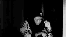 a black and white photo of a woman wearing a beanie .