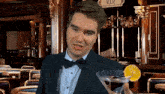 a man in a suit and bow tie is holding a martini glass