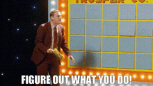 a man in a suit and tie is standing in front of a board that says " figure out what you do " .