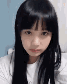 a close up of a girl with long black hair and bangs looking at the camera .