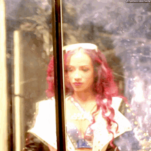 a woman with red hair is standing in front of a glass door with the next thing written on the bottom