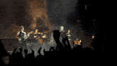 a crowd at a concert watching a band perform with a sign that says off