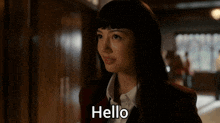 a woman says hello in a hallway in a dark room