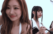 a woman with a ponytail is standing next to another woman with long hair