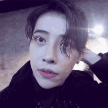a close up of a person 's face with a light shining on it
