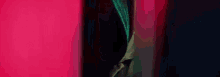 a close up of a person standing in front of a red wall .