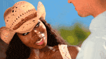 a woman wearing a cowboy hat looks at a man in a white shirt